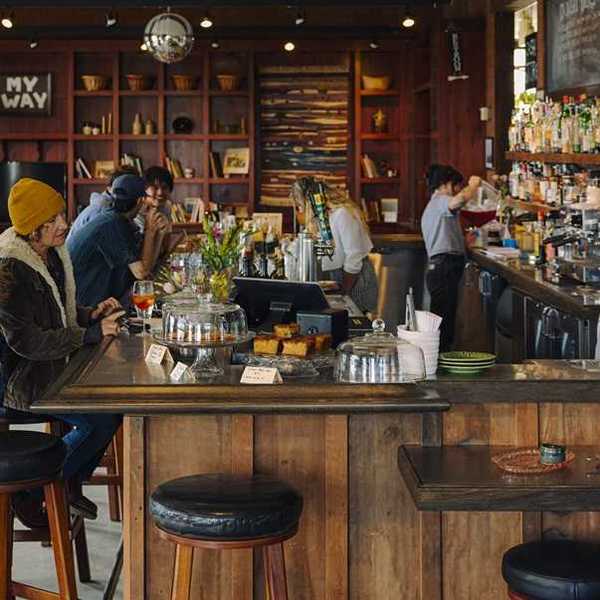 people sitting at a cozy, rustic bar with stylish shelves in the background