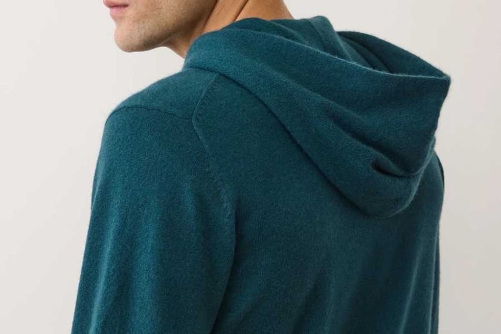 Person wearing a teal hoodie, shown from behind.