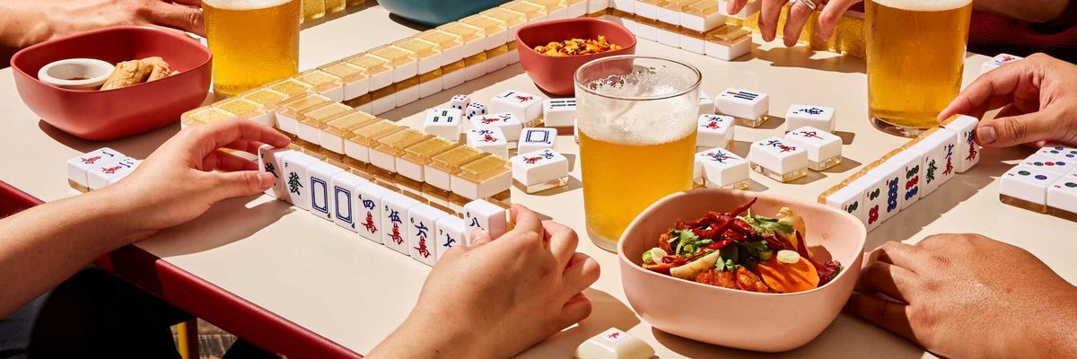 players at a mahjong table with food and beer