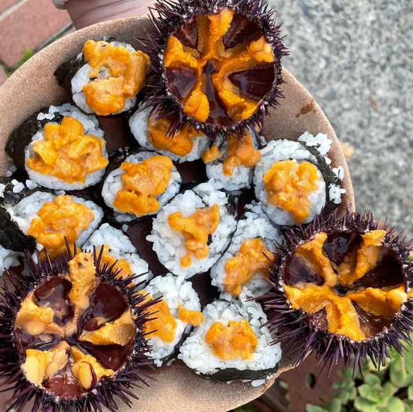 purple sea urchin with their insides exposed and sushi rolls with uni on top