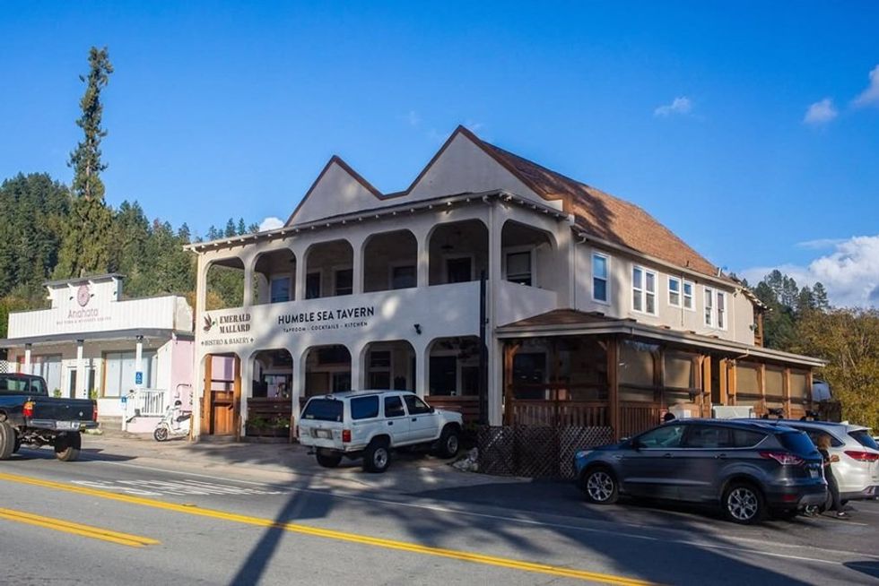 Street view of Humble Sea Tavern with parked cars and a clear blue sky.