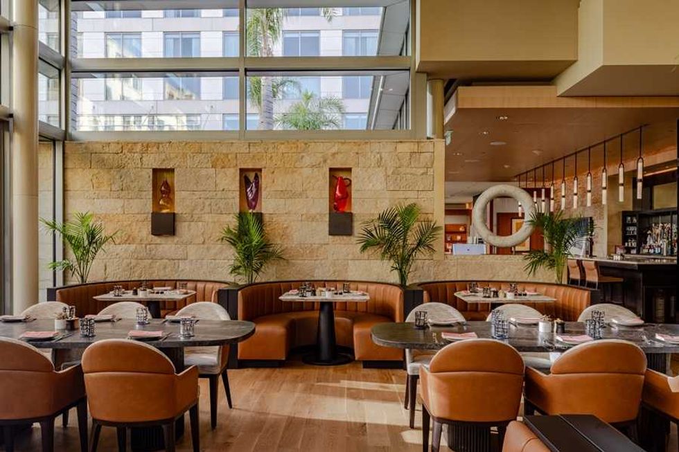 Stylish restaurant interior with curved booths, modern decor, and large windows.