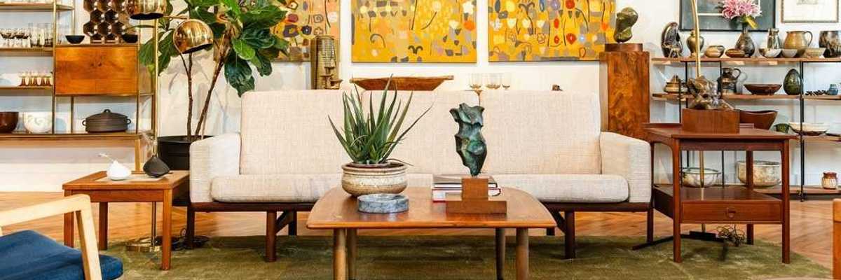 the inside of a furniture store with a couch and a painting behind it and lots of shelves with things on them