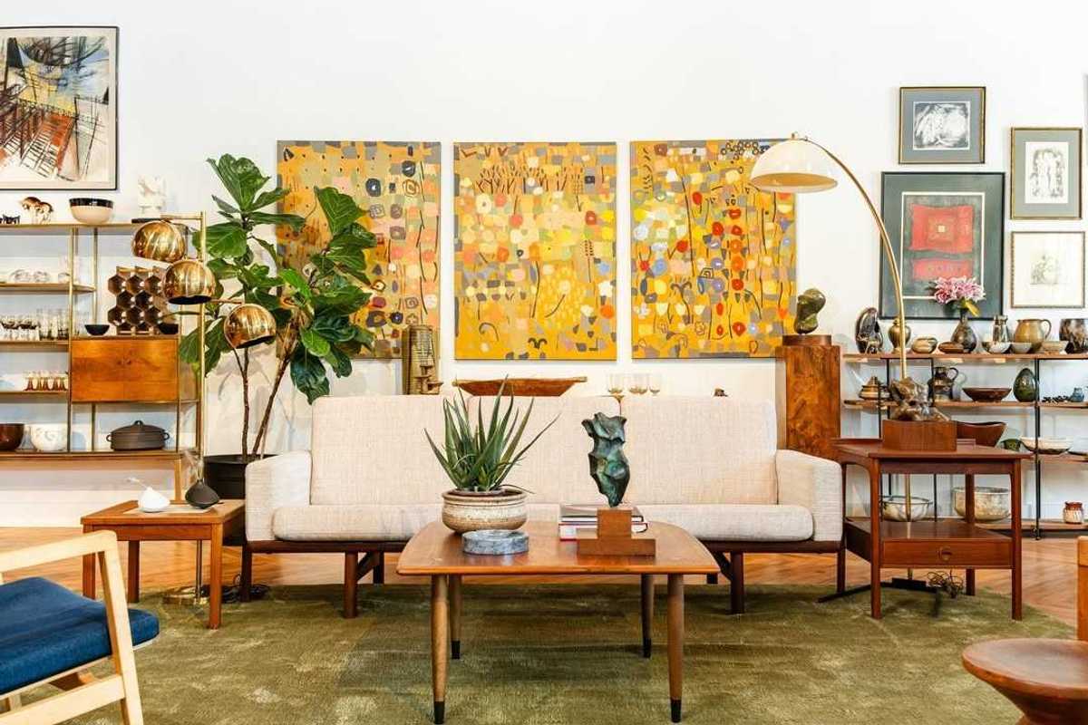 the inside of a furniture store with a couch and a painting behind it and lots of shelves with things on them