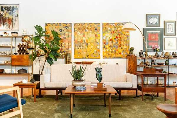 the inside of a furniture store with a couch and a painting behind it and lots of shelves with things on them