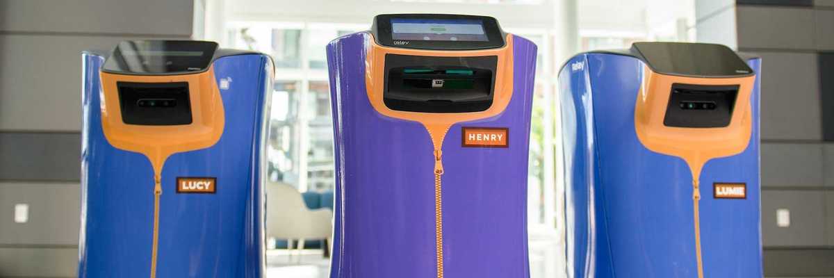 three hospitality robots at a hotel