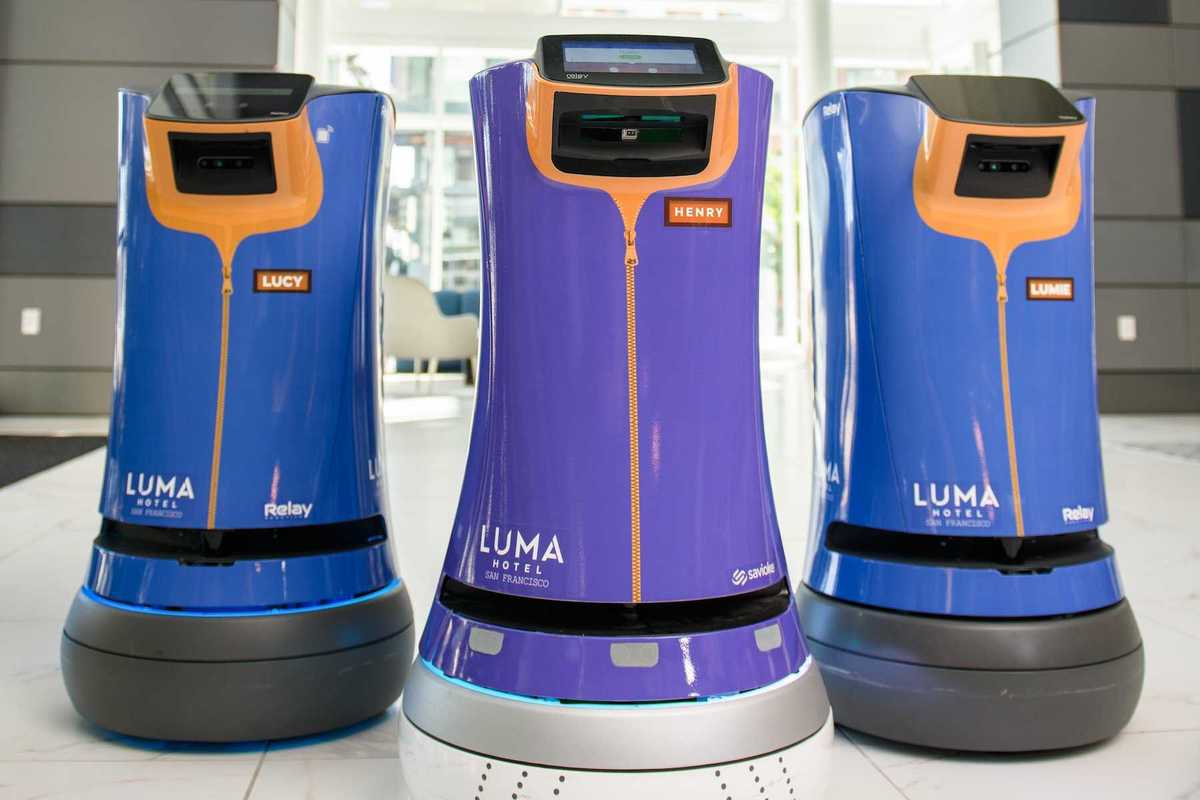 three hospitality robots at a hotel