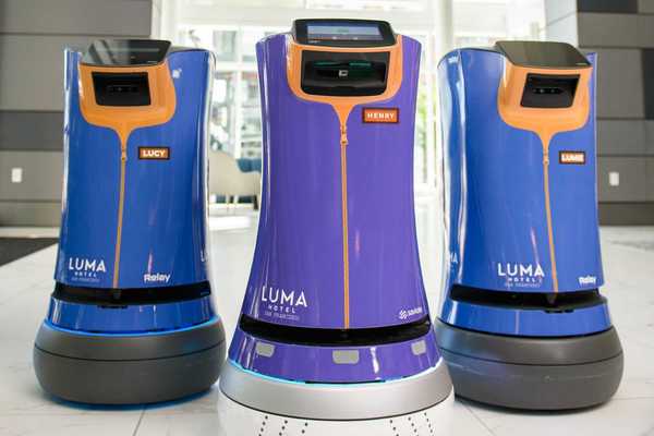 three hospitality robots at a hotel