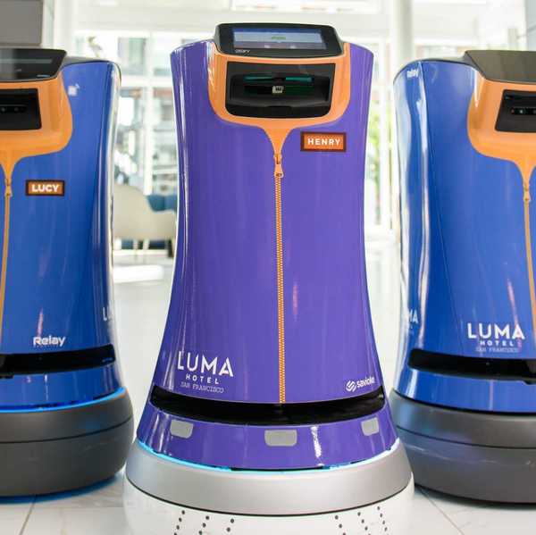 three hospitality robots at a hotel