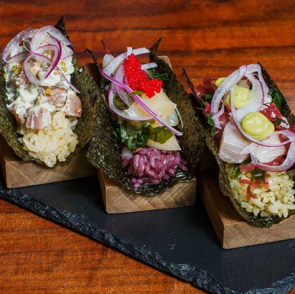 three Japanese Peruvian-style handrolls on a slate tray