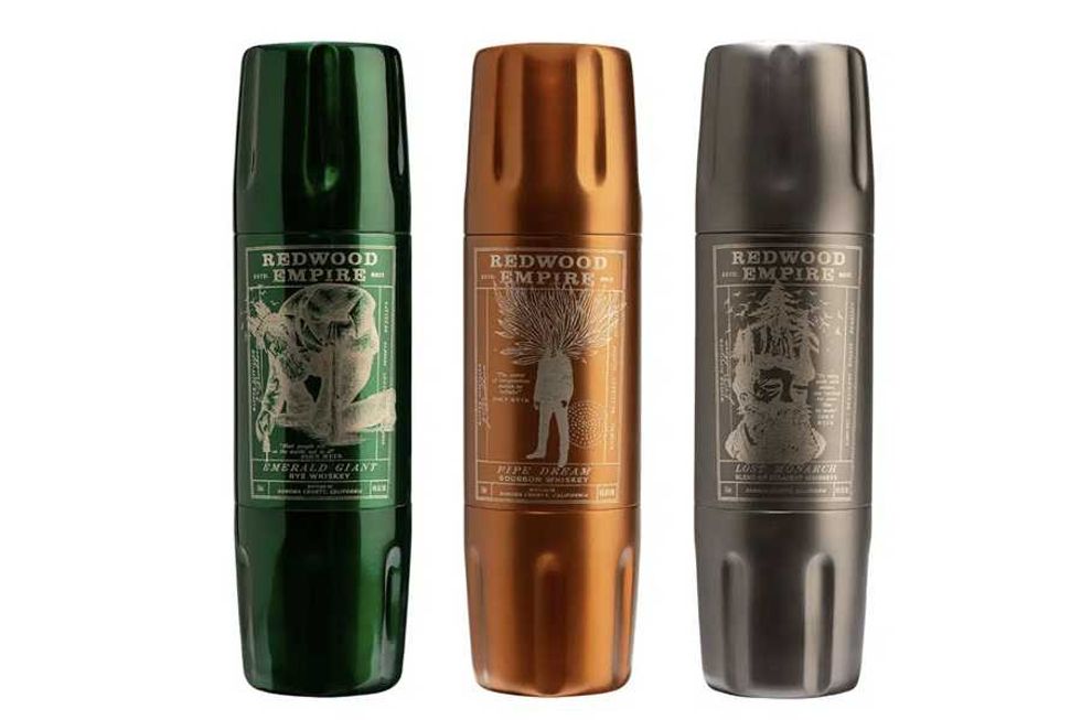 Three Redwood Empire whiskey cans in green, orange, and gray with detailed label art.