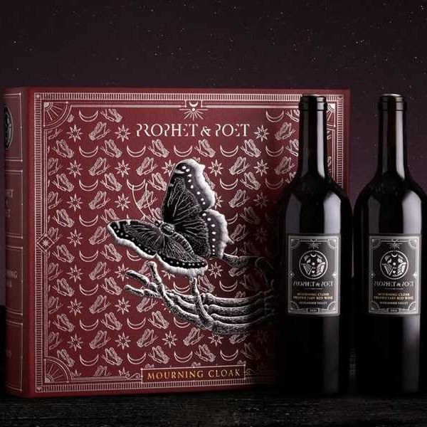 Three wine bottles beside a detailed red box with a butterfly design.