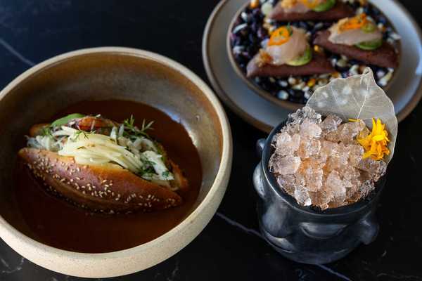 two Mexican food dishes and a cocktail with ice and a leaf sticking out