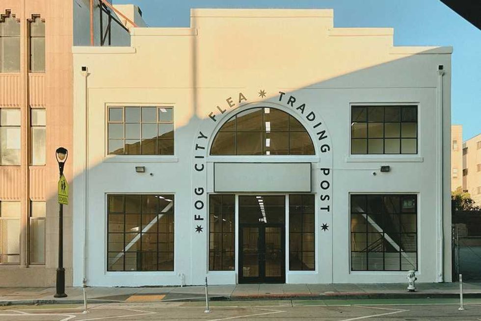 White building labeled "Fog City Flea Trading Post" with large windows and arched entrance.