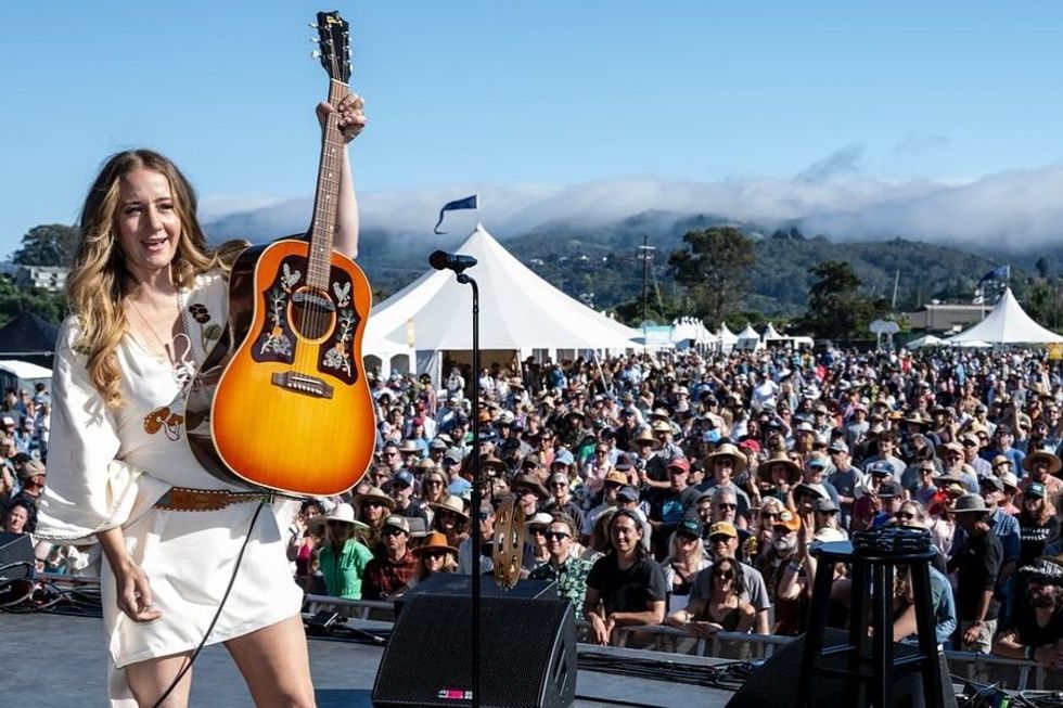 woman with a guitar on stage