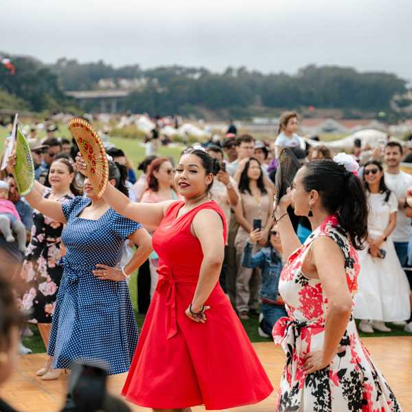 women dancing with fans in a park